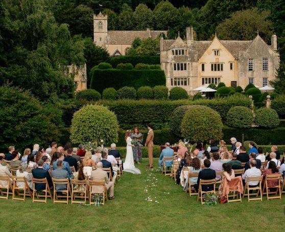 An aerial shot of a wedding taking place in front of a manor house